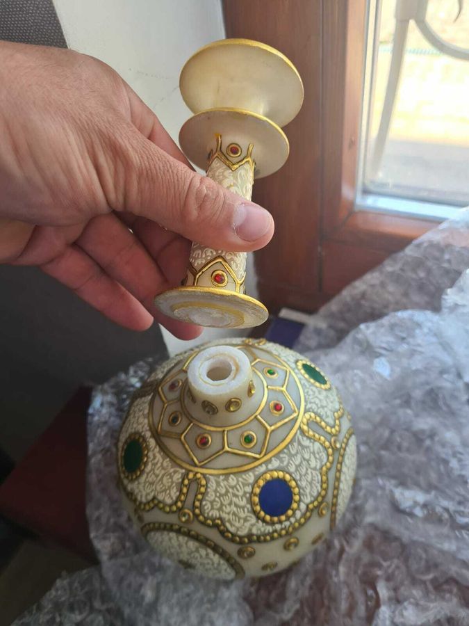 Ваза с инкрустацией, расколотая на две части, в руках